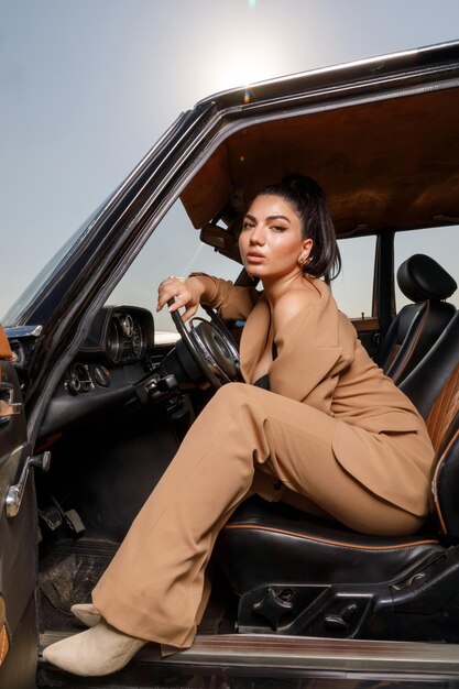 Young hot model sitting on a driver seat and looking at the camera High quality photo