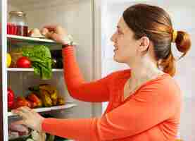 Free photo young housewife near refrigerato