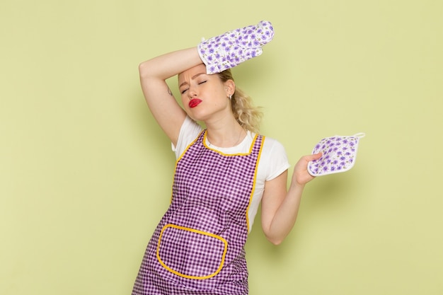 young housewife in shirt and purple cape tired of housework on green