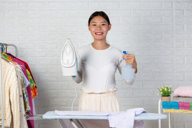 The young housewife who is satisfied with her iron On a white brick .