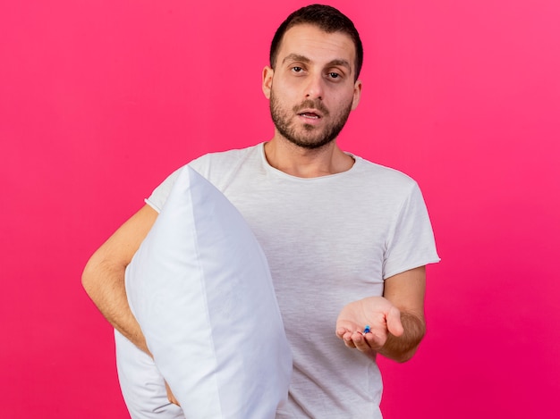 Foto gratuita cuscino della holding del giovane uomo malato con le pillole isolate su priorità bassa dentellare