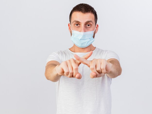 Young ill man wearing medical mask and scarf showing gesture of no isolated on white