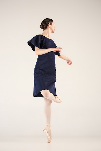 Young and incredibly beautiful ballerina is dancing in a blue studio