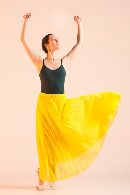 Free photo young and incredibly beautiful ballerina is dancing at studio