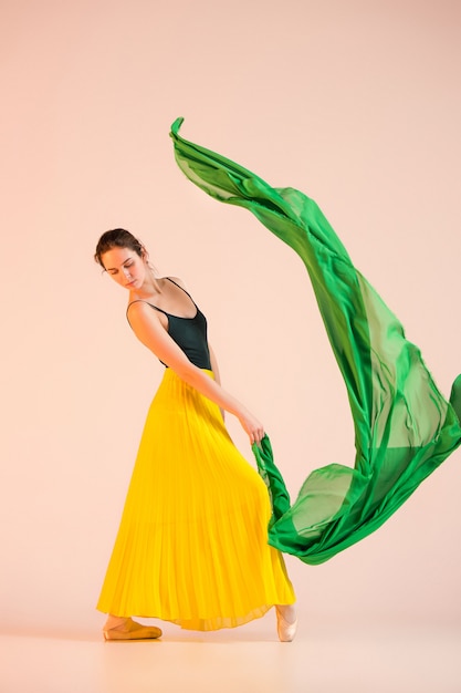 Free photo young and incredibly beautiful ballerina is dancing at studio