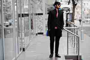 Free photo young indian man on suit tie and sunglasses posed outdoor