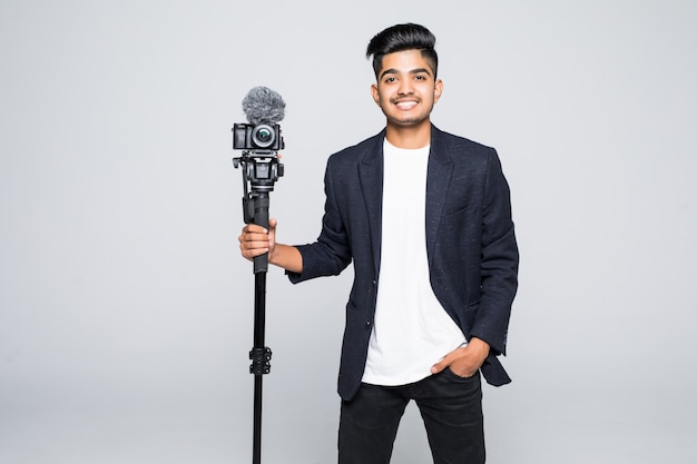 Free photo young indian man video camera operator isolated on white background.