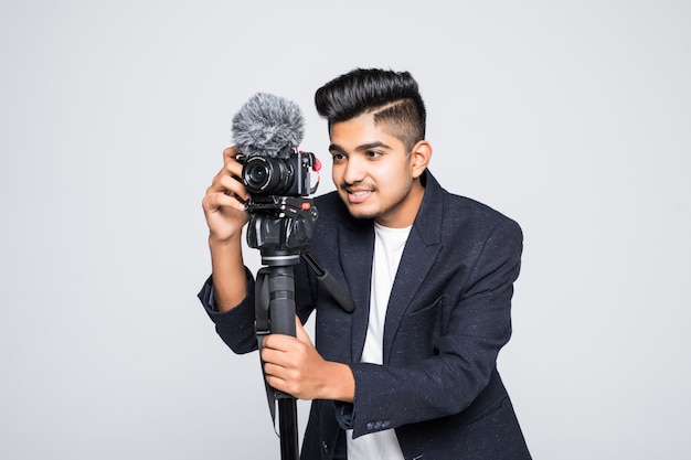 Young indian man video camera operator isolated on white background.