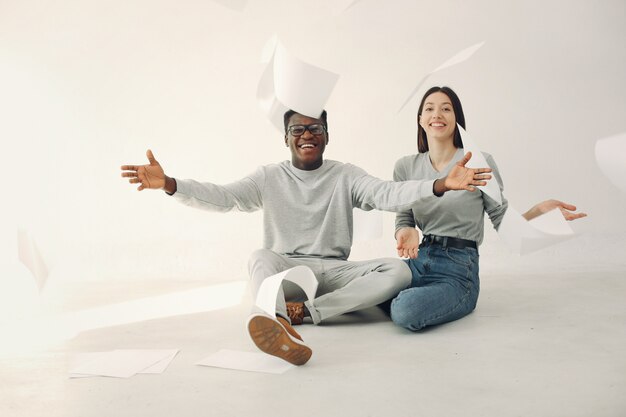 Young international people sitting with documents in the studio