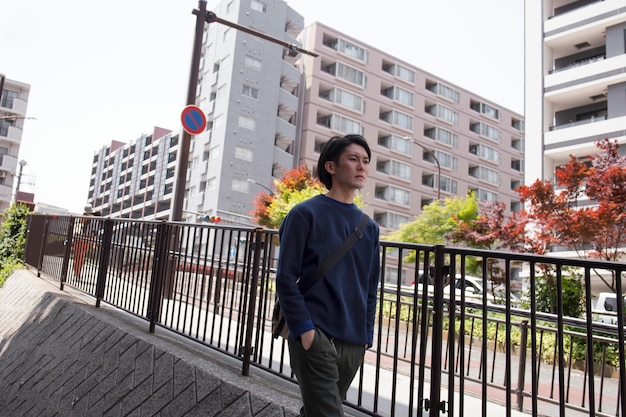 Young japanese man in a blue sweater in the city