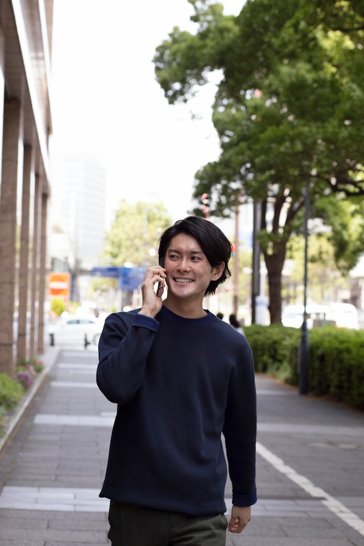 無料Photo 屋外で青いセーターを着た若い日本人男性