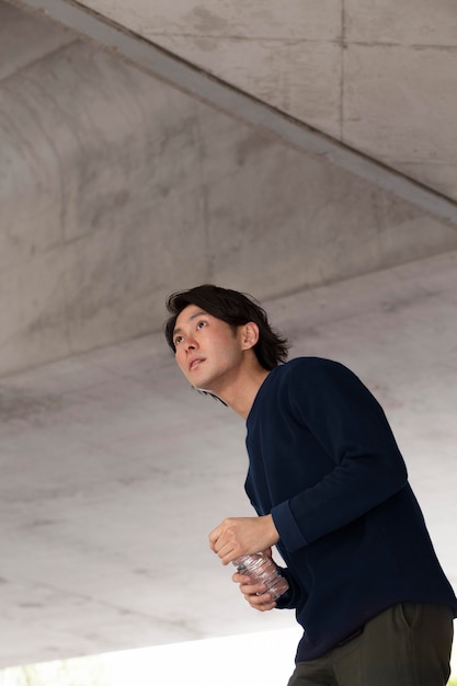 屋外で青いセーターを着た若い日本人男性
