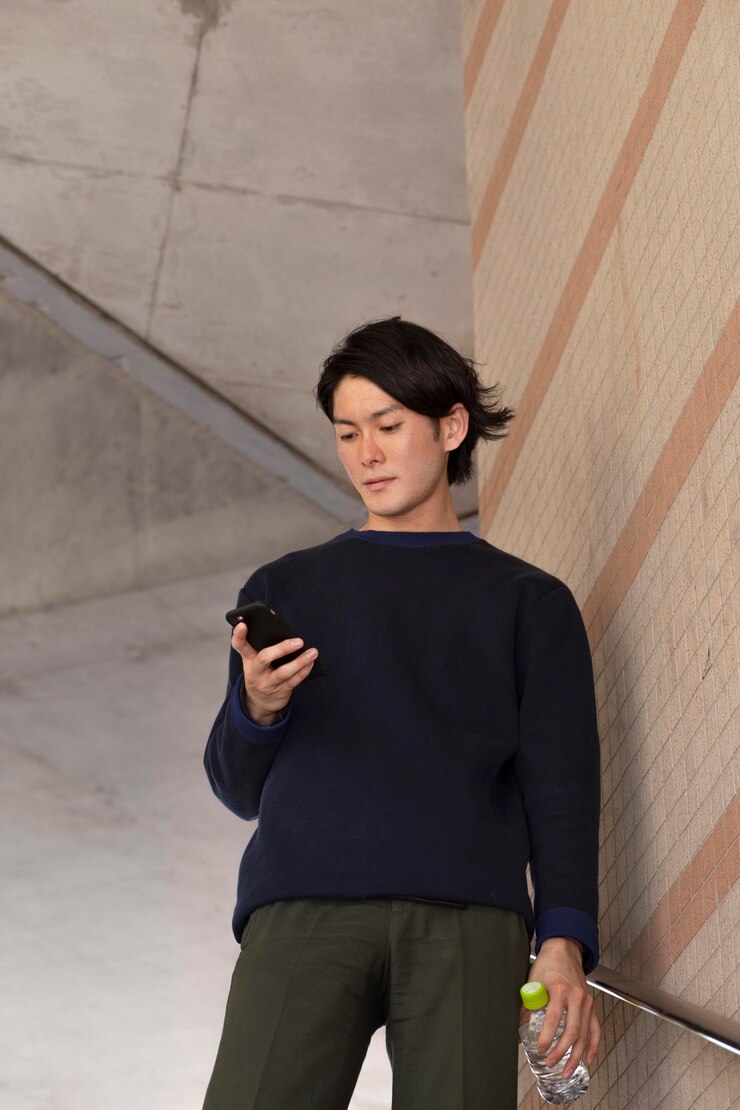 無料Photo 屋外で青いセーターを着た若い日本人男性