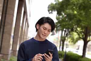 무료 사진 블루 스웨터 야외에서 젊은 일본 남자