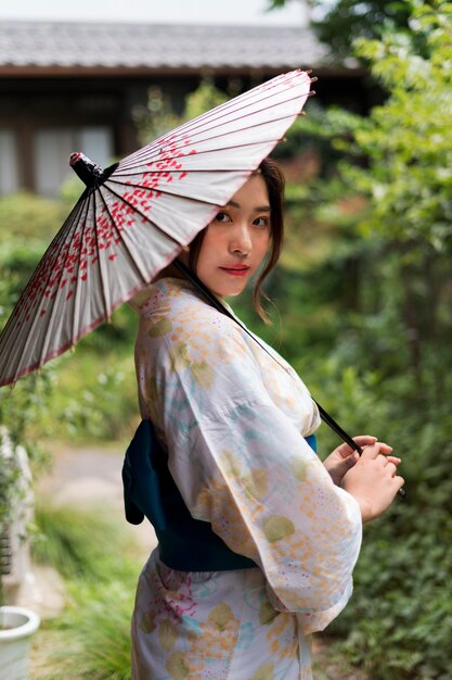 기모노를 입고 우산을 들고 있는 젊은 일본 여성