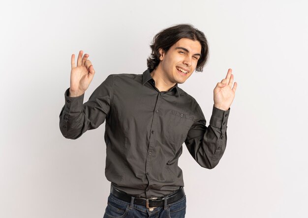 Young joyful handsome caucasian man gestures ok hand sign isolated on white background with copy space