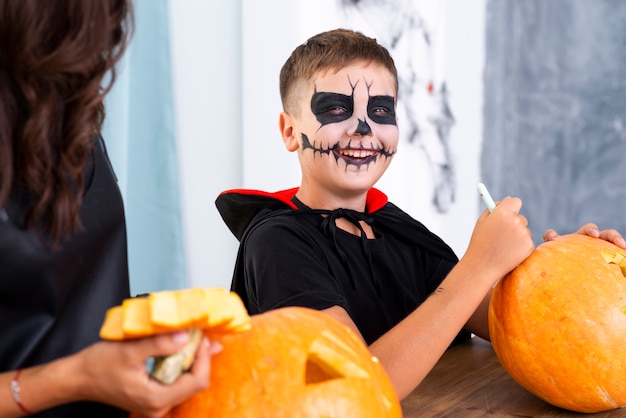 Young kid carving pumpkin for halloween 