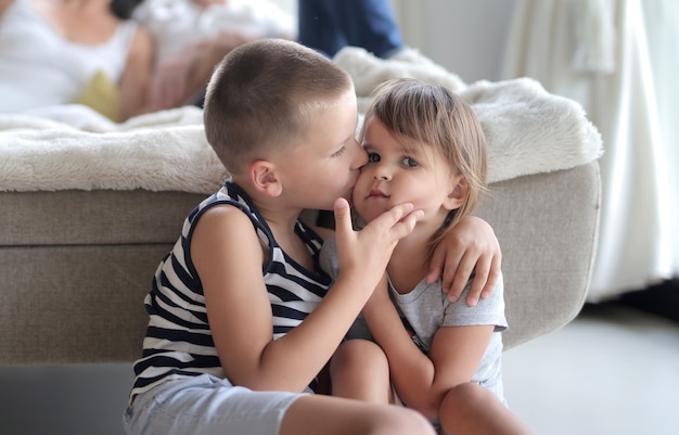 ライトの下で妹の頬にキスする幼い子供