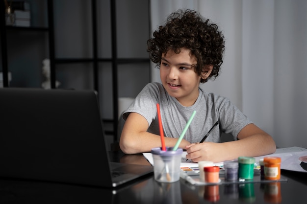 Free photo young kid painting with watercolor