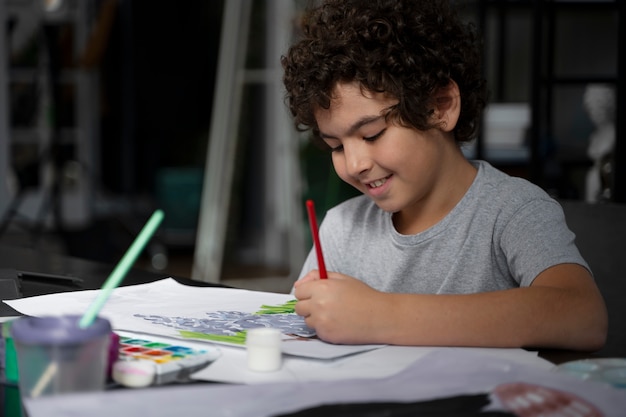 Бесплатное фото Молодой ребенок рисует акварелью