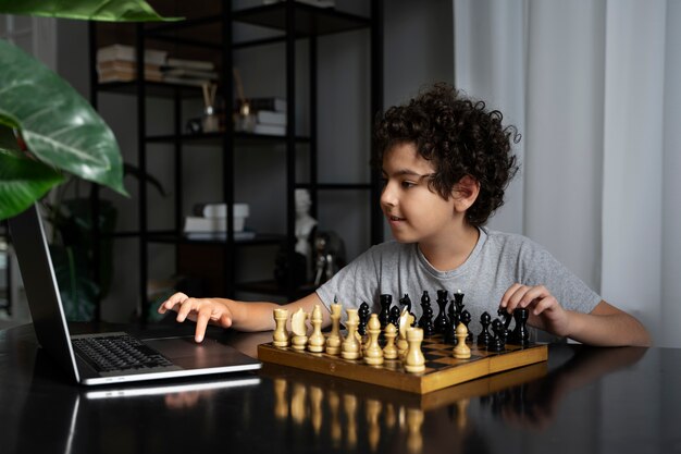 Молодой ребенок играет в шахматы