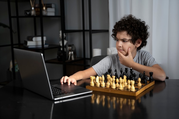 Молодой ребенок играет в шахматы