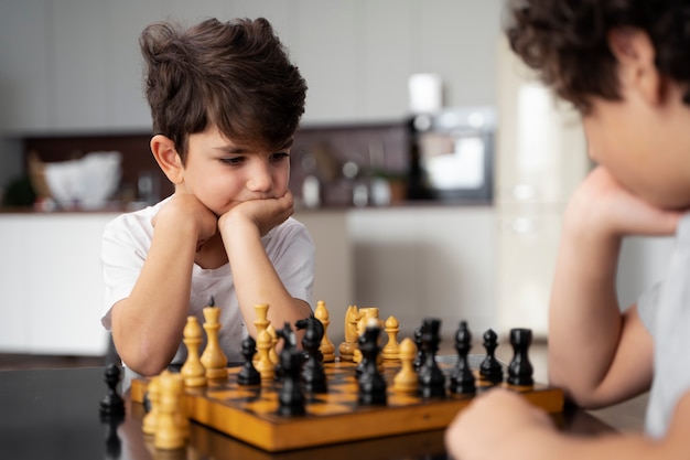 Маленькие дети вместе играют в шахматы