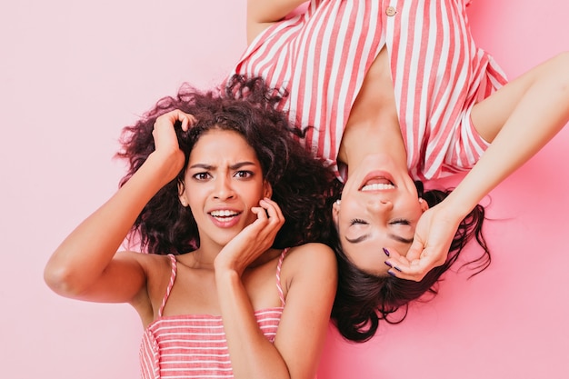 Foto gratuita giovani donne con bellissimi occhi marroni e trucco carino, vestite con abiti firmati alla moda di colore rosa