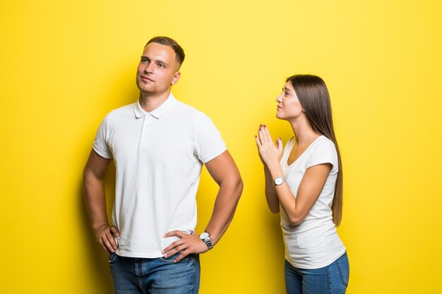 Young lady ask her boyfriend to do something isolated on yellow background