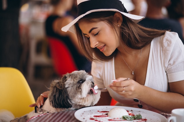 Молодая леди в баре с милой собакой, с обедом