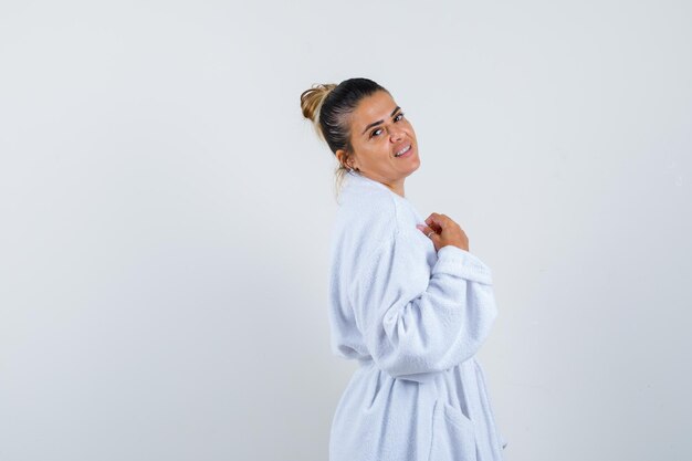 Young lady in bathrobe looking over her shoulder and looking positive