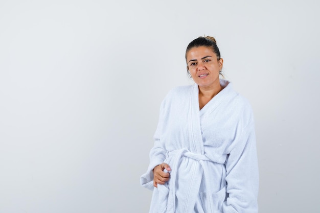 Free photo young lady in bathrobe posing while standing and looking pretty