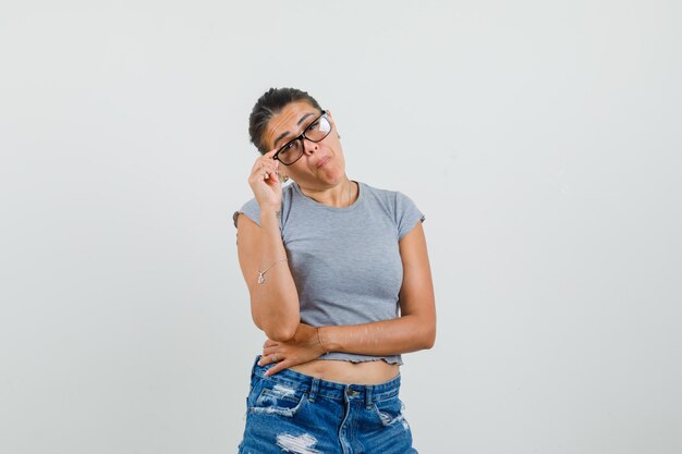 Young lady being scornful about something in t-shirt, shorts and looking funny