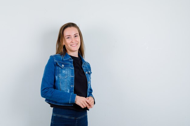 Young lady in blouse looking at camera and looking confident , front view.