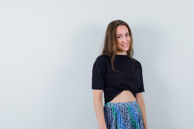 Free photo young lady in blouse, skirt looking at camera and looking jolly