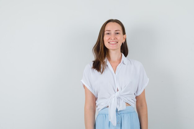 Young lady in blouse and skirt smiling while looking at front and looking positive