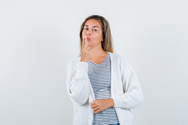 Young lady blowing on finger pistol in t-shirt, jacket and looking confident , front view.