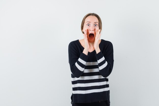 Young lady in casual shirt shouting or announcing something