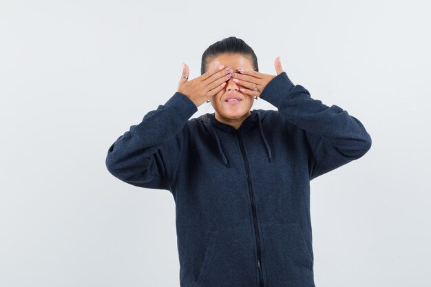 Young lady covering her eyes with hands in jacket 