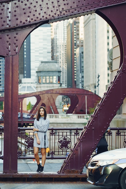 Free photo young lady crossing the bridge in the city