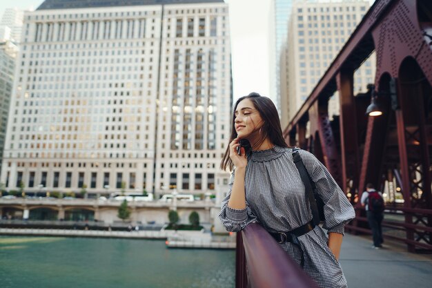 young lady crossing the bridge in the city