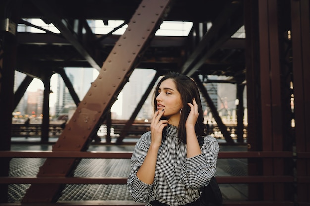 young lady crossing the bridge in the city