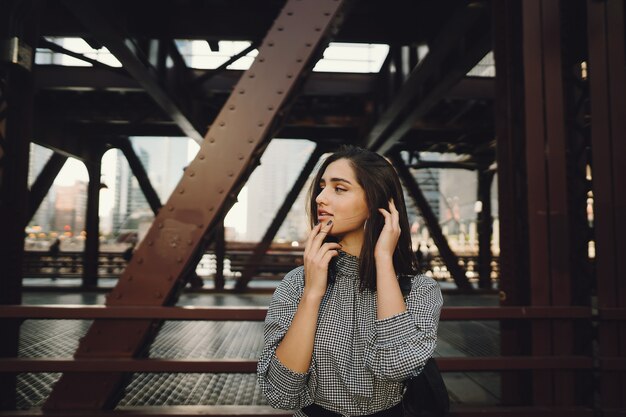 young lady crossing the bridge in the city