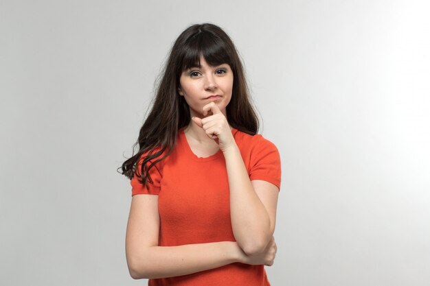 young lady in designed t-shirt thinking with long hair on white