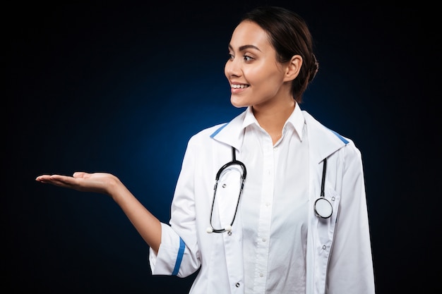 Young lady doctor holding copy space on hand