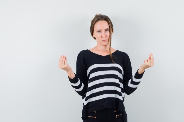 Young lady doing Italian gesture in casual shirt and looking sensible