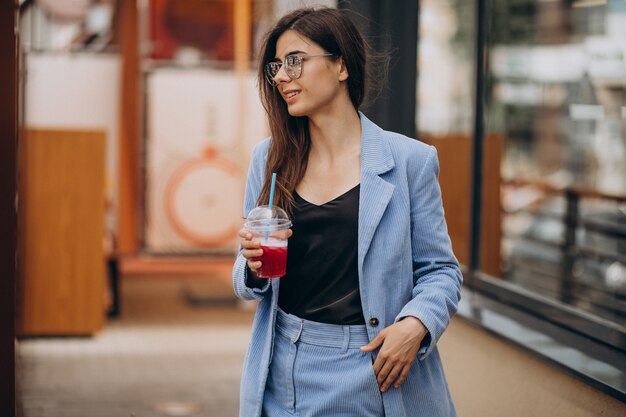 Free photo young lady drinking ice drink outside the street