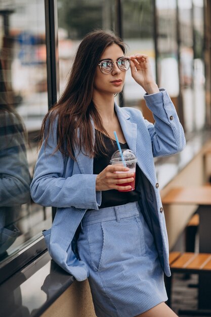 Young lady drinking ice drink outside the street