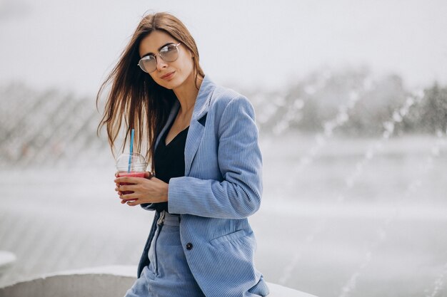 Young lady drinking ice tea in park