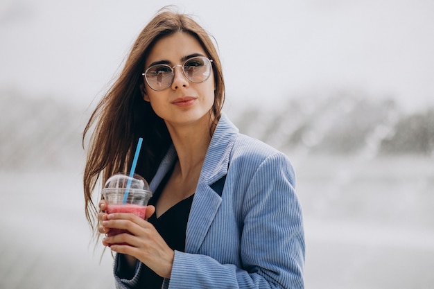 Free photo young lady drinking ice tea in park